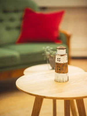 Ein Leuchtturm auf einem Tisch bei Vertrauenswelt. Der Leuchtturm ist ebenfalls im Logo von Vertrauenswelt verankert.