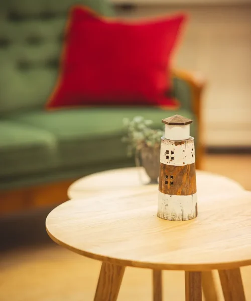 Ein Leuchtturm auf einem Tisch bei Vertrauenswelt. Der Leuchtturm ist ebenfalls im Logo von Vertrauenswelt verankert.