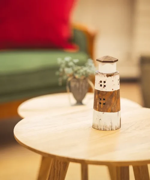 Ein Leuchtturm auf einem Tisch bei Vertrauenswelt. Der Leuchtturm ist ebenfalls im Logo von Vertrauenswelt verankert.