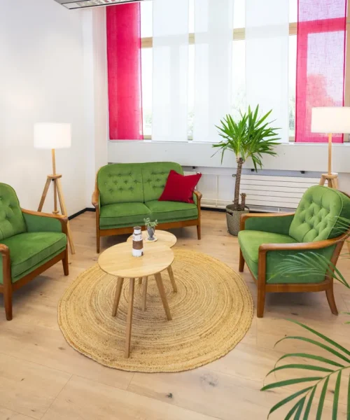 Der Praxisraum von Vertrauenswelt in Wetzikon. Ein heller gemütlicher Raum mit Holzboden und grünen bequemen Sesseln.